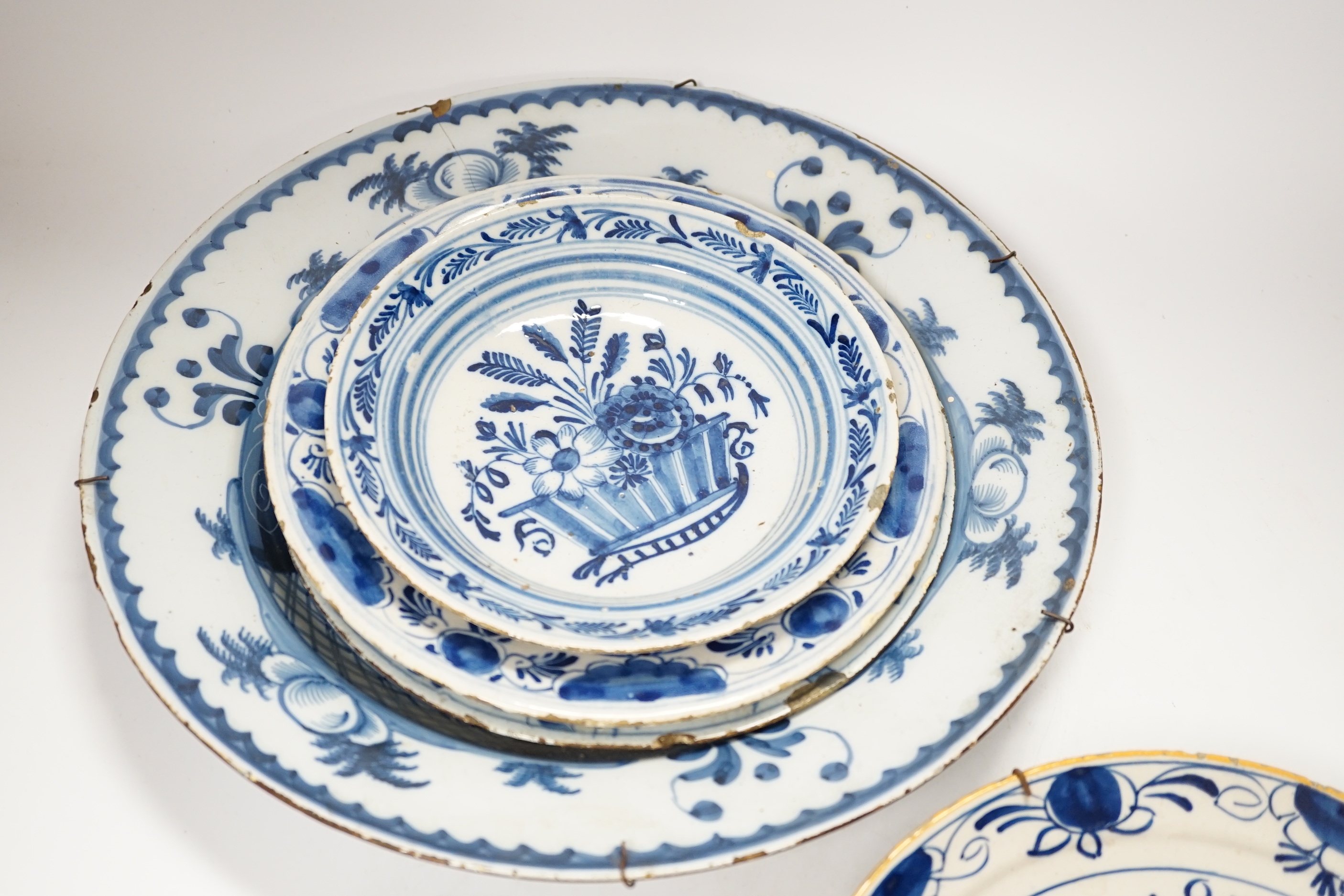 Five 18th century assorted Delft dishes and a plate, largest 35cm diameter